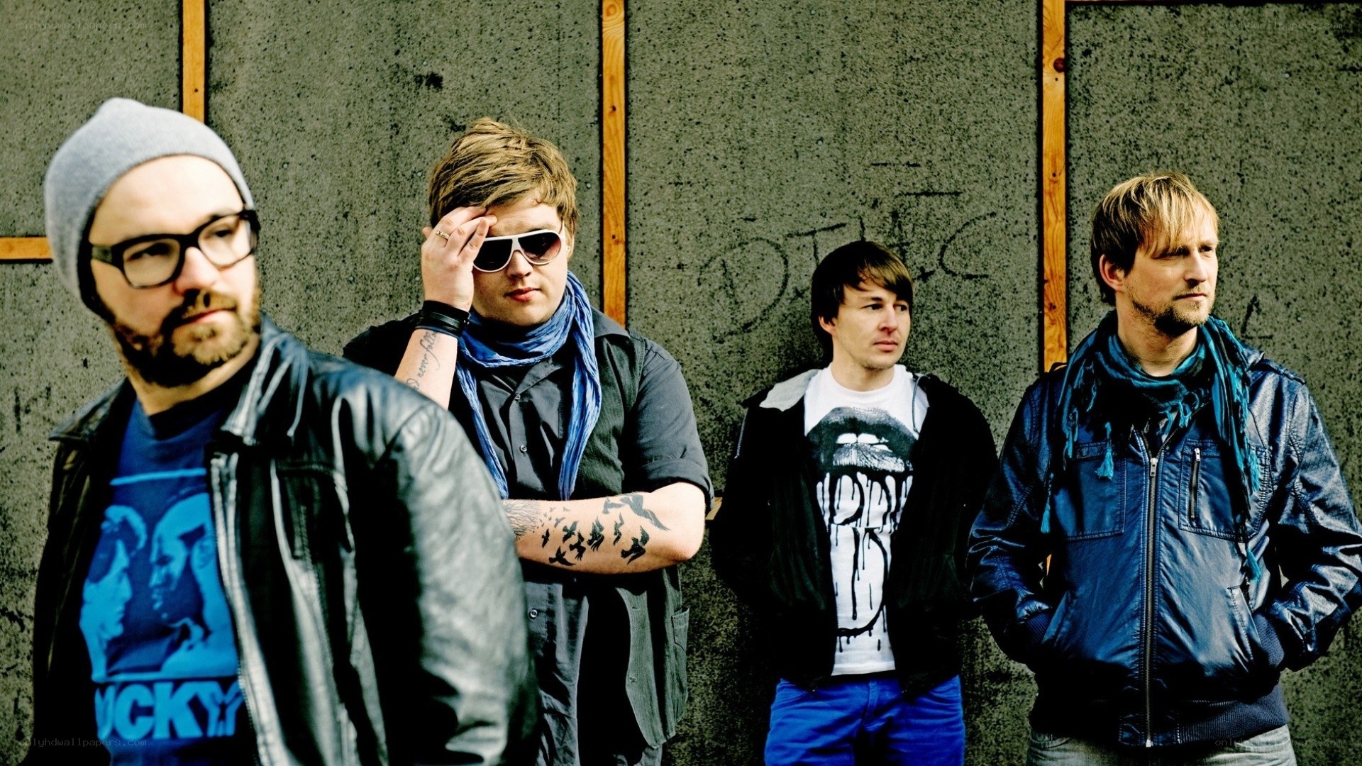 band members posing against wall