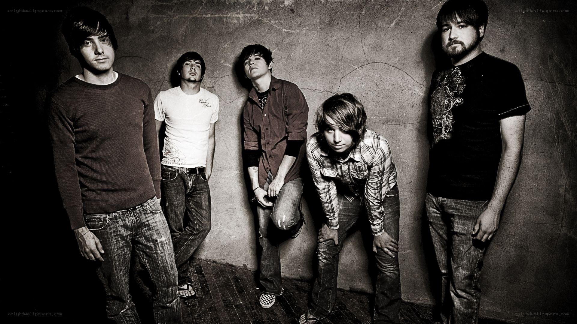 band members posing against wall