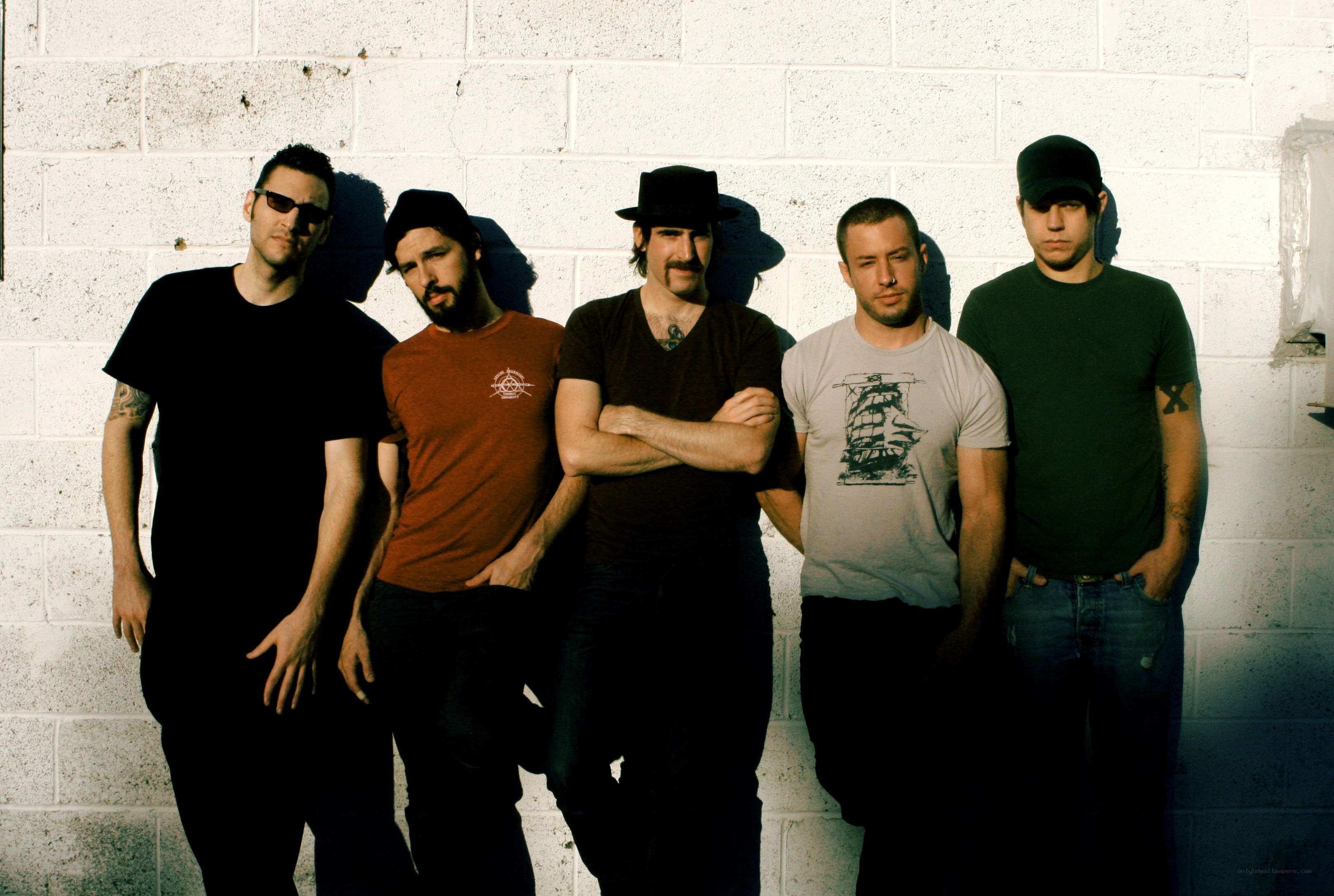 band members posing against wall