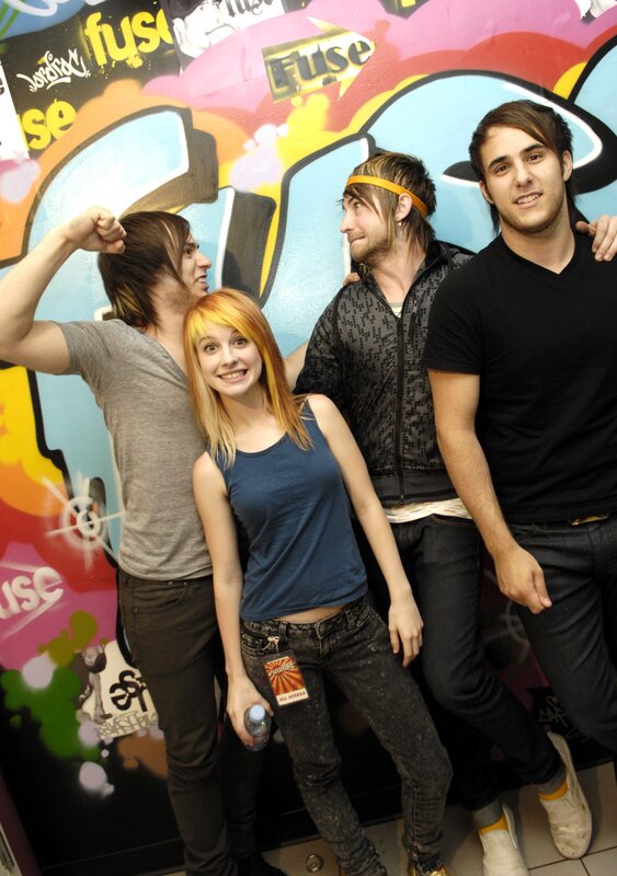 band members posing in front of graffiti