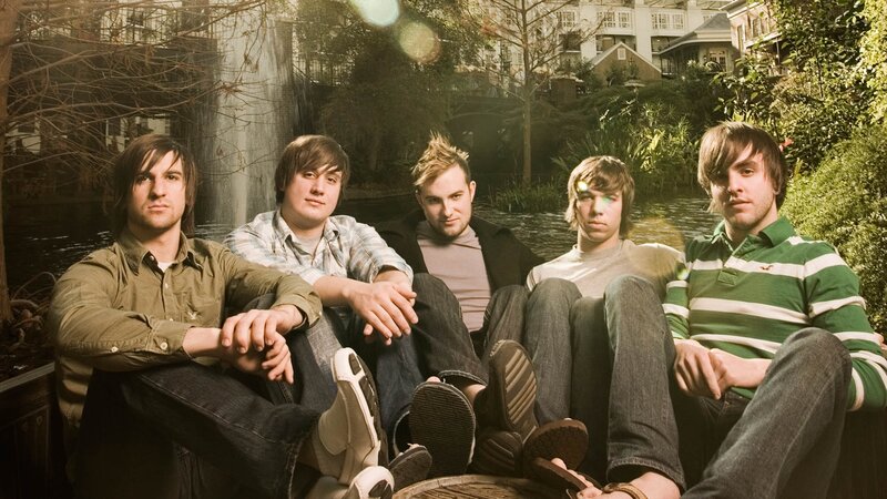 band members sitting by a pond