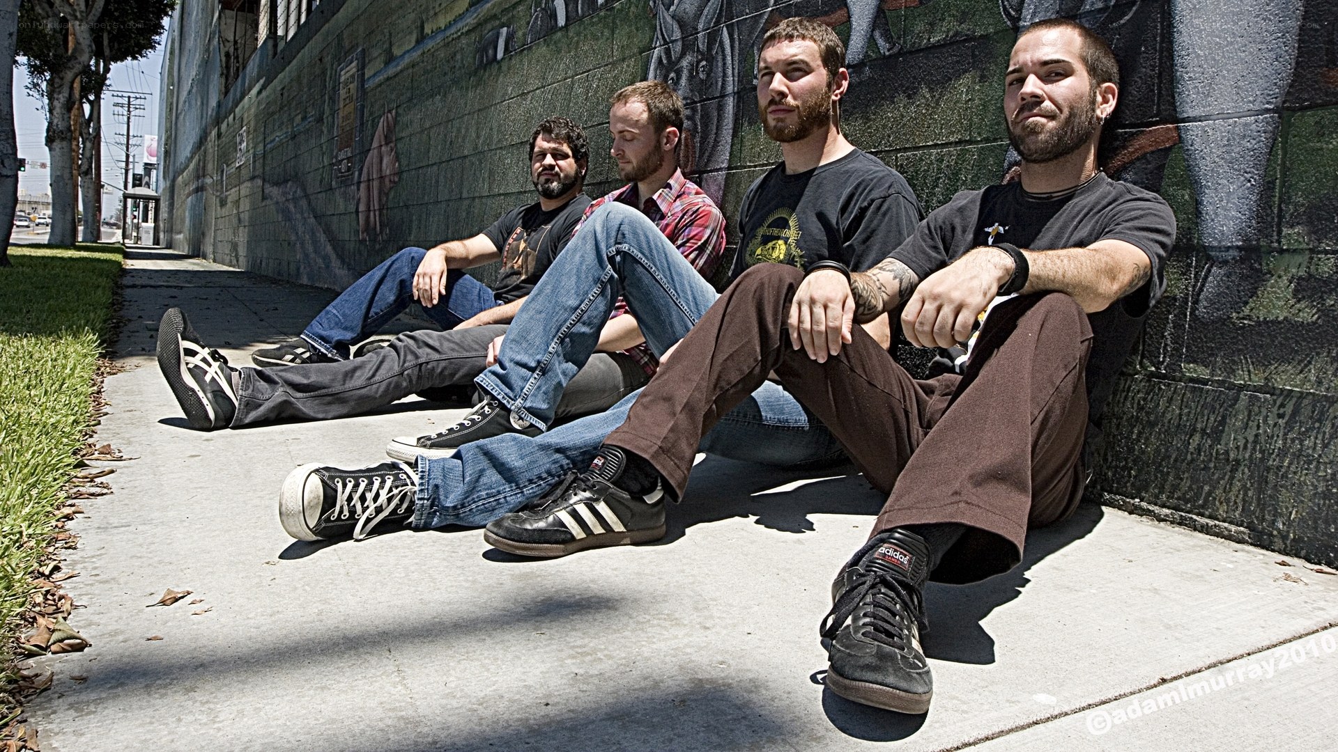 band members sitting on sidewalk