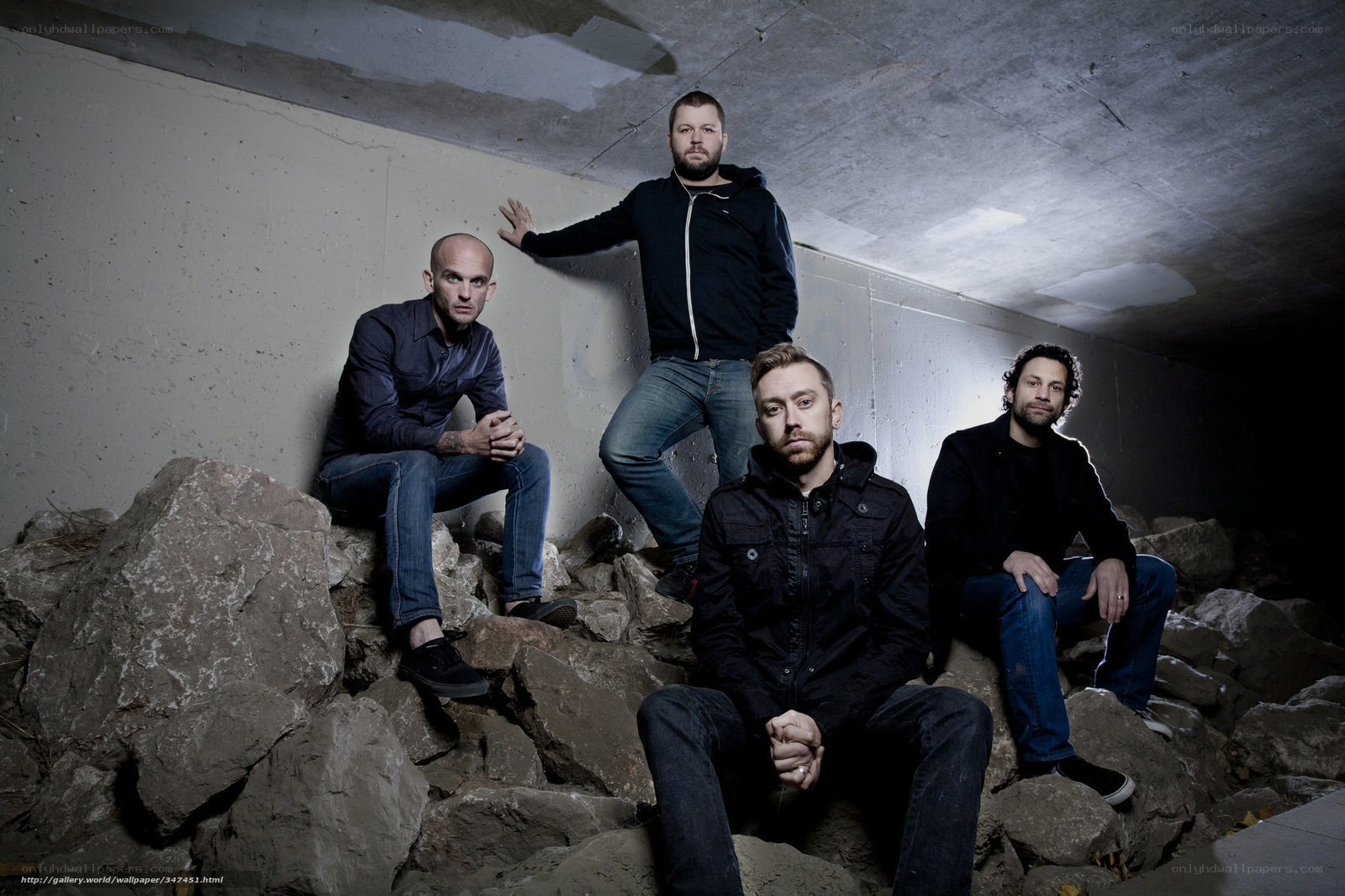 band on rocks under bridge
