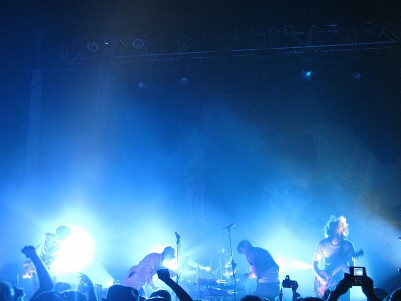 Band Performing on Stage — Blue, Energetic, Night, Photograph, Crowd, Guitarist