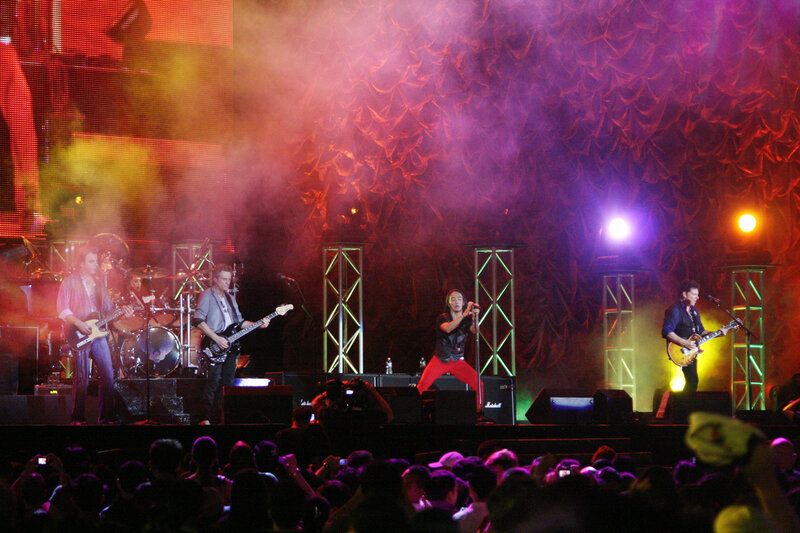 Band Performing on Stage — Red, Energetic, Night, Photograph, Guitarists, Drummer, Singer