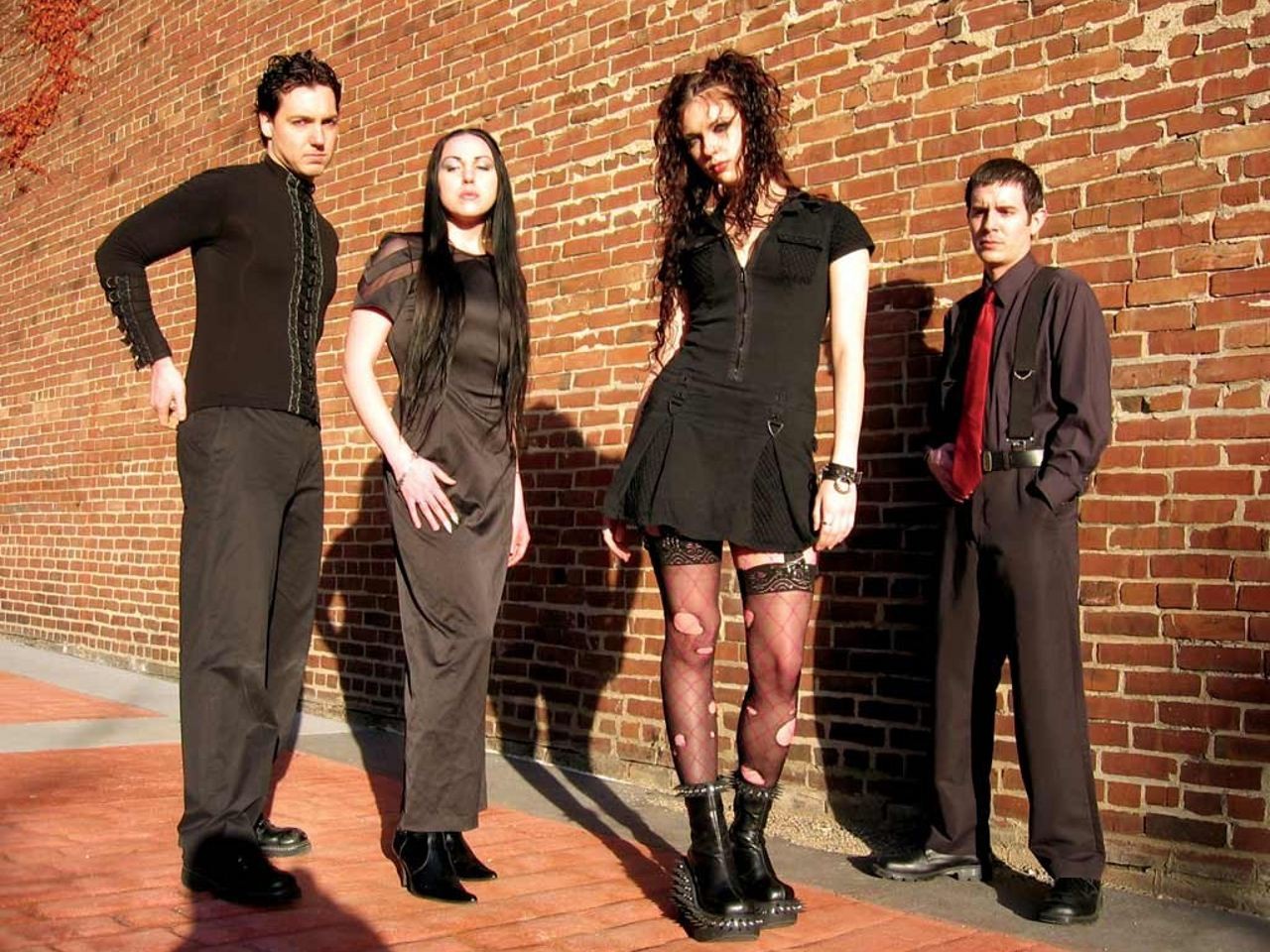 band posing against brick wall