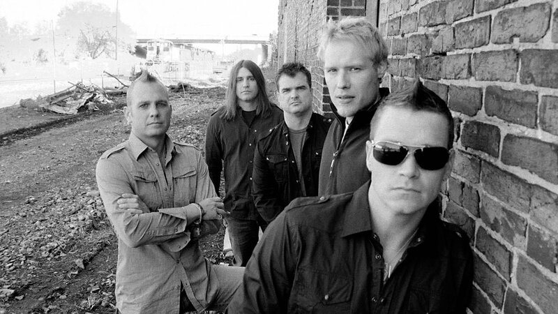 band posing by brick wall