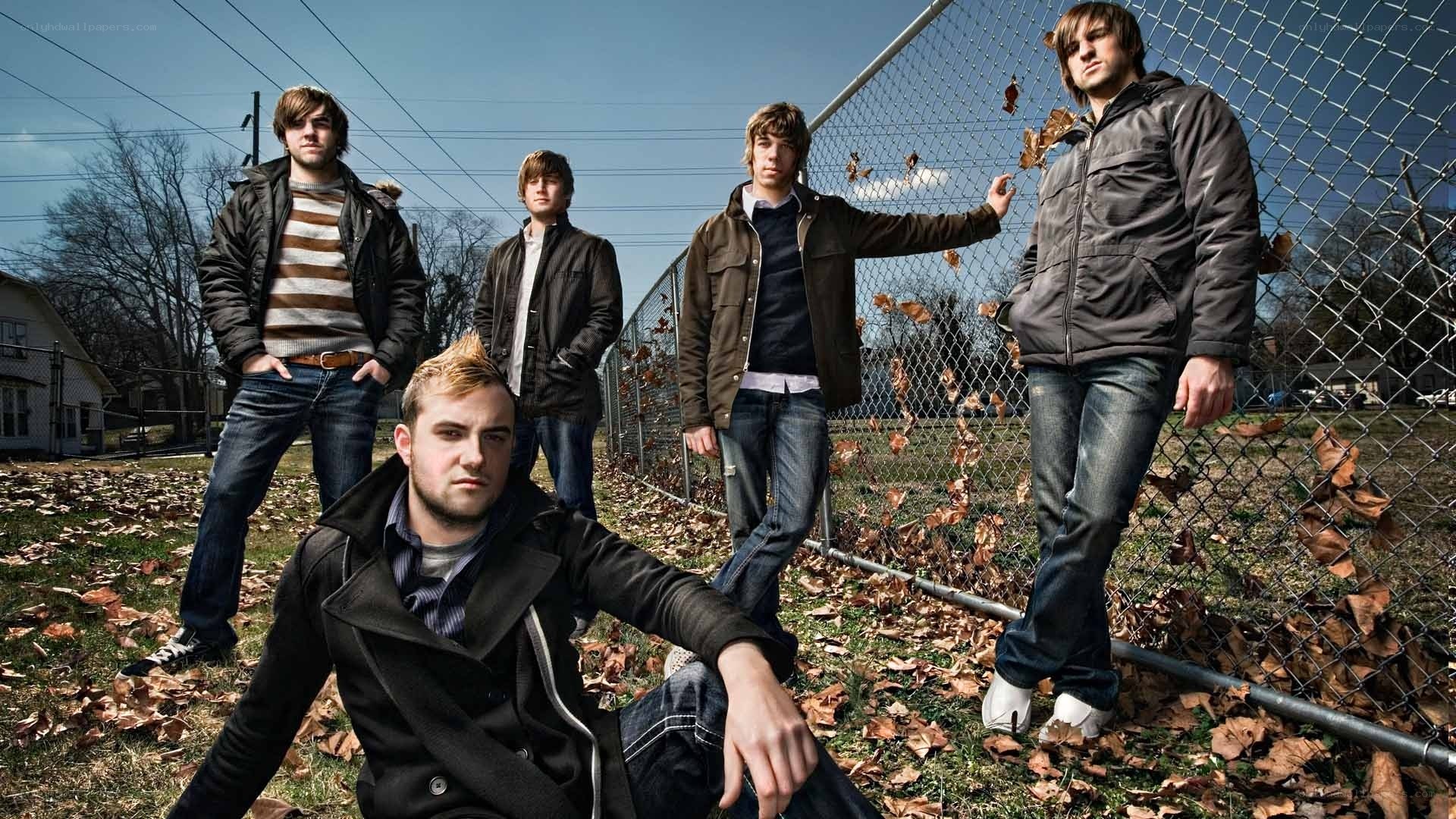 band posing by fence