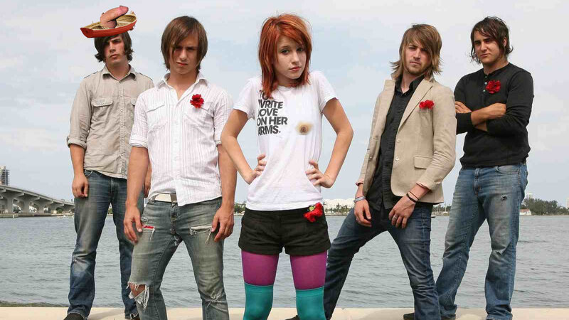band posing by the water