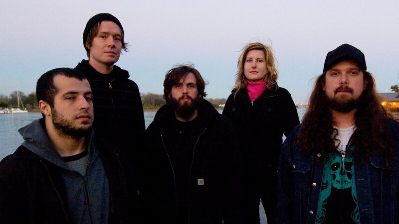 band posing by the water