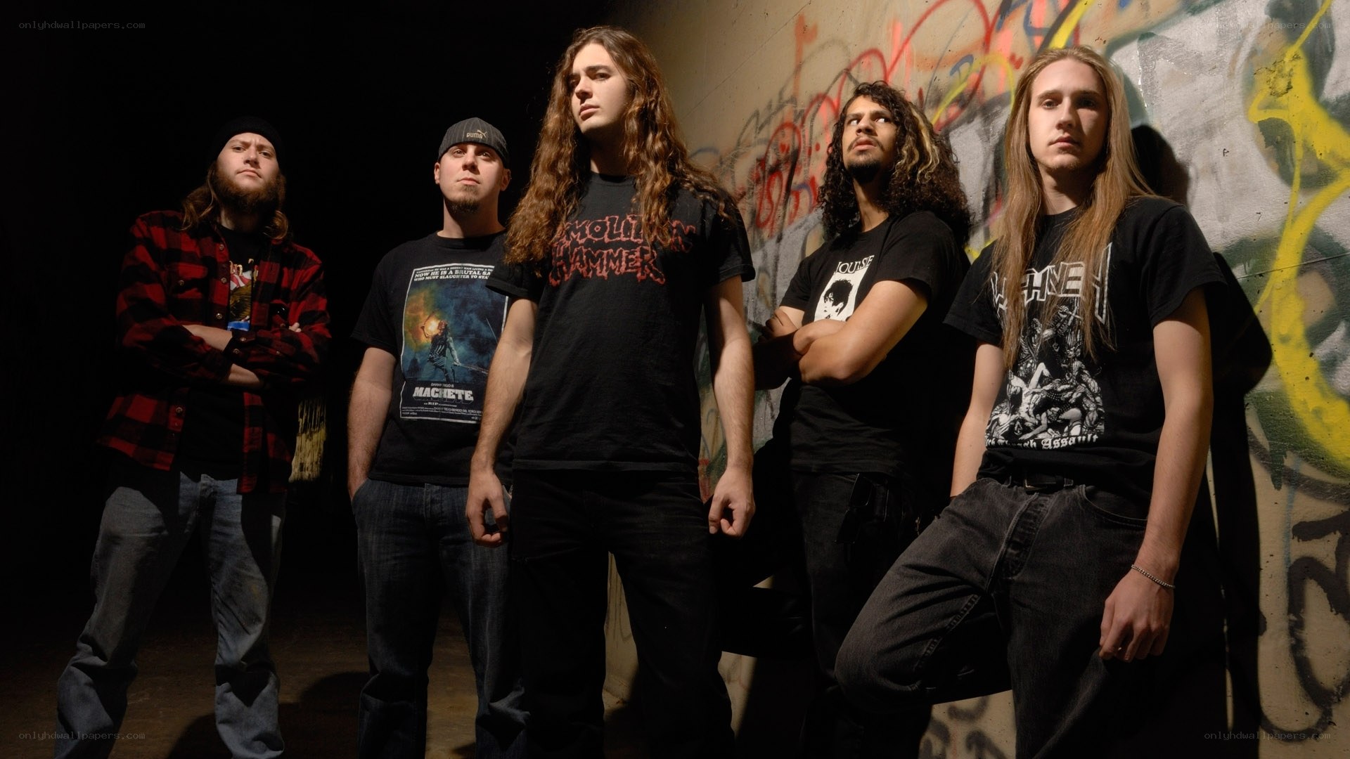 band posing in front of graffiti wall