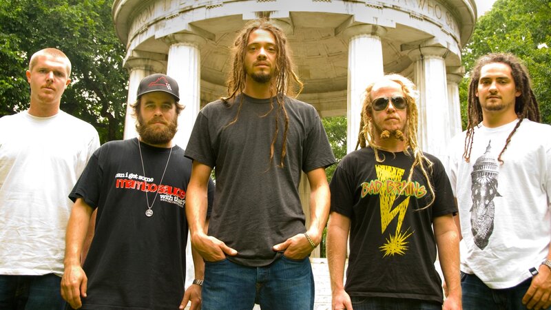band posing in front of monument