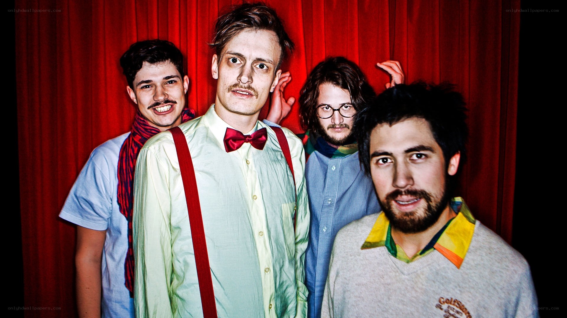band posing in front of red curtain