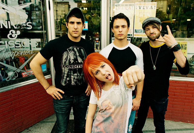 band posing in front of shop