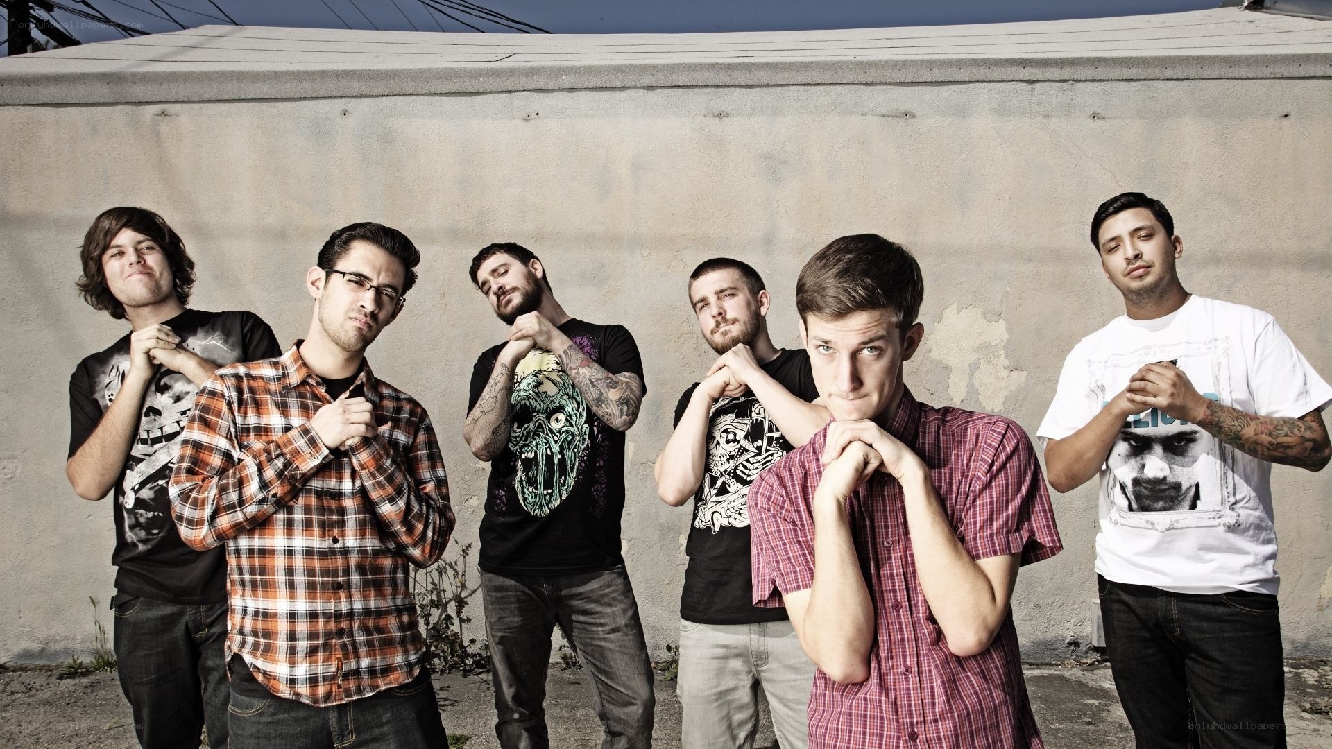 band posing in front of wall