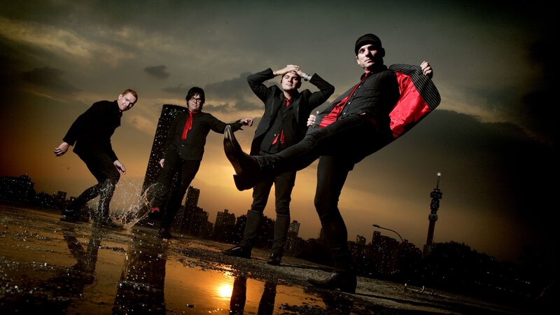 band posing on wet rooftop