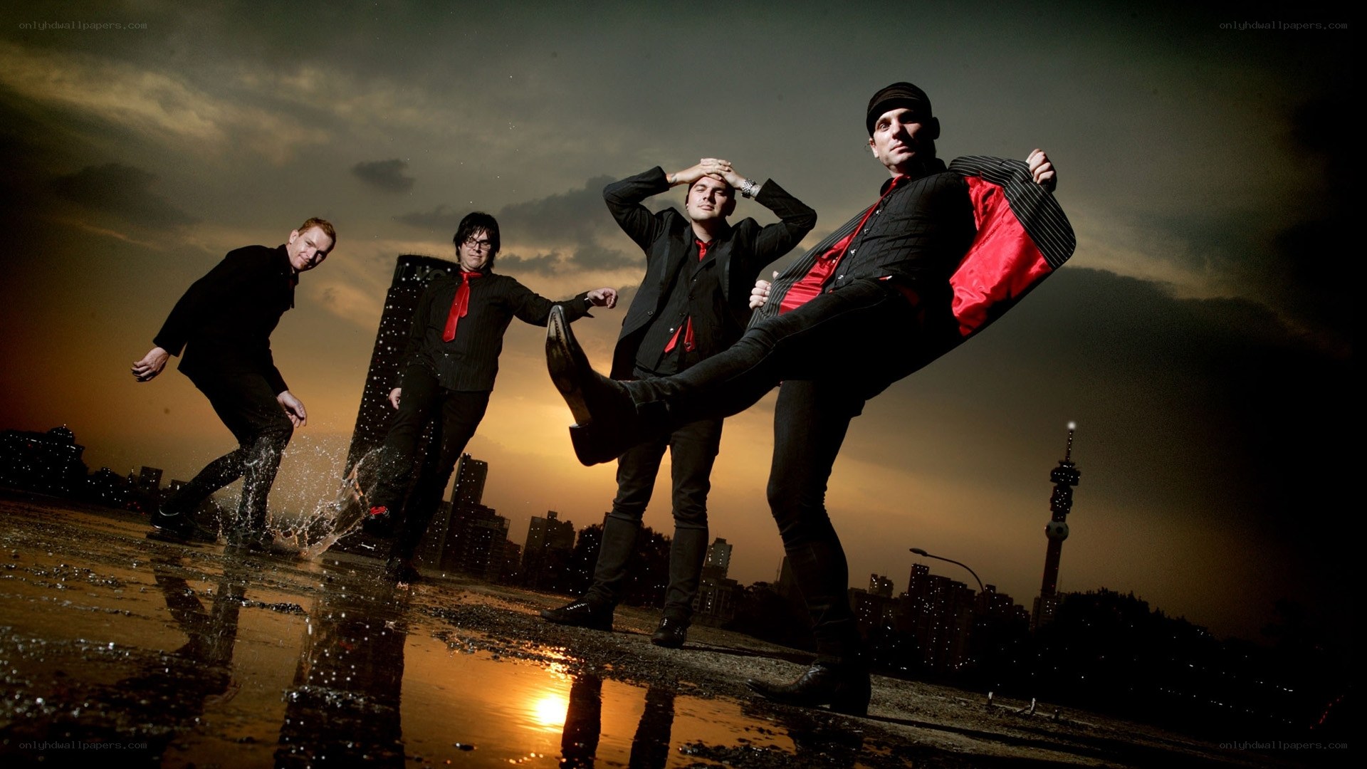 band posing on wet rooftop