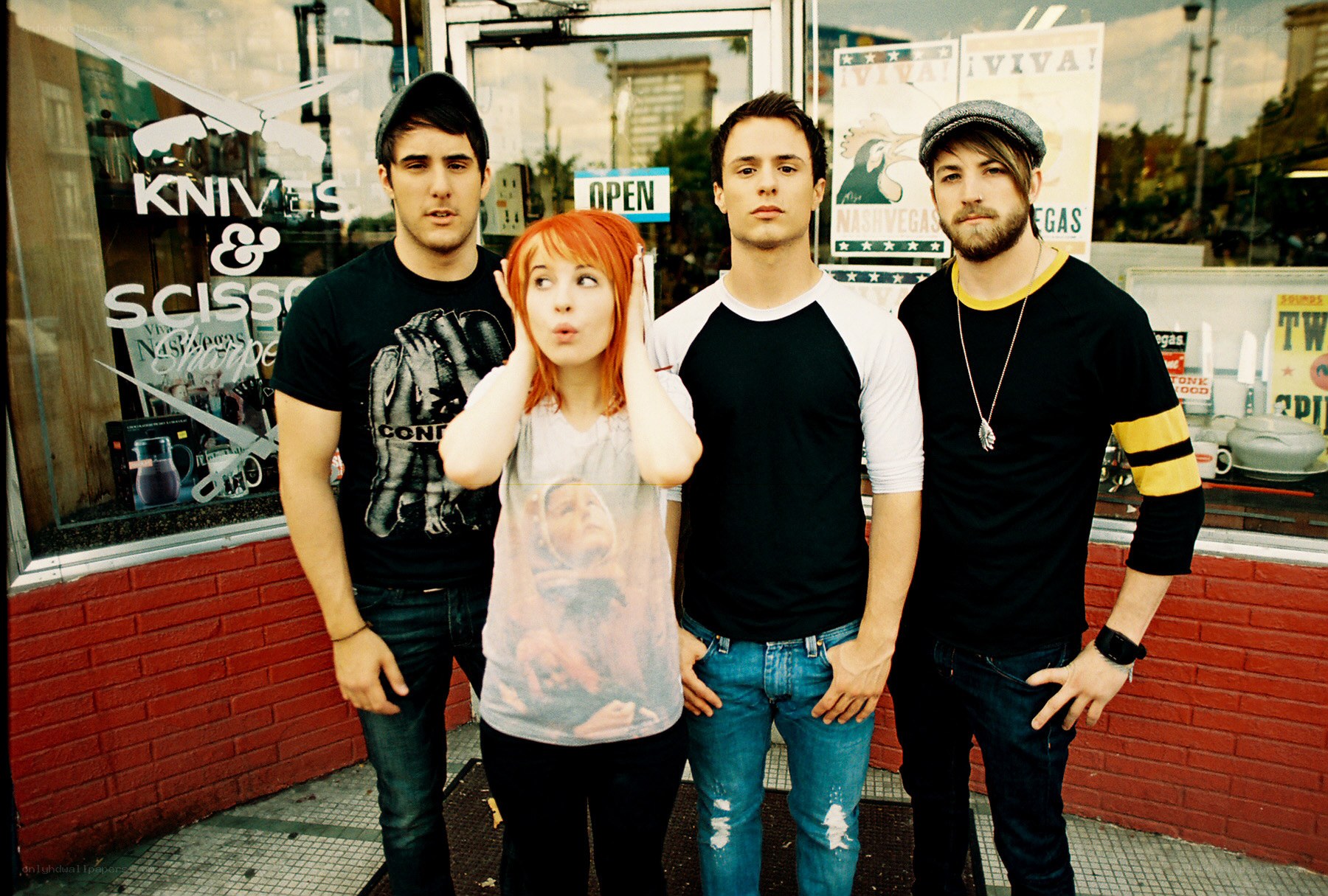 band posing outside a shop