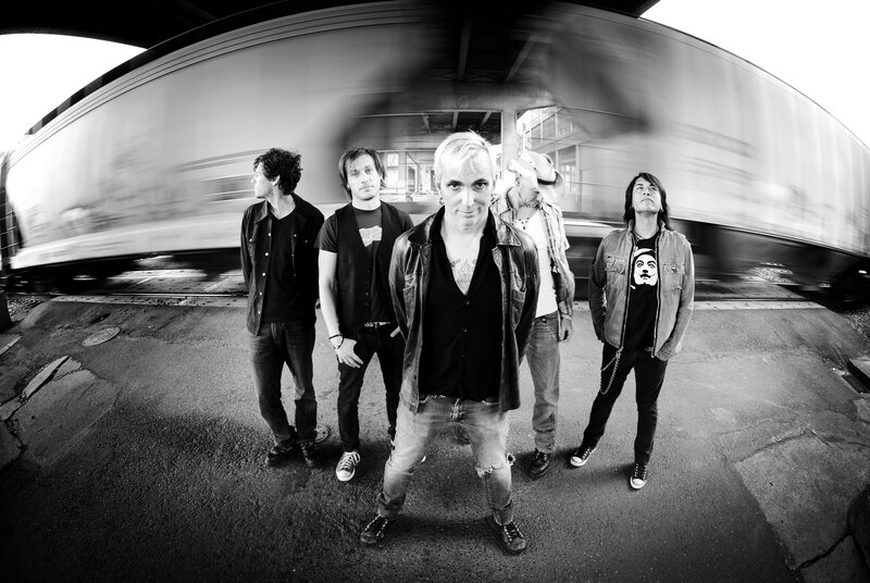 band posing under a train