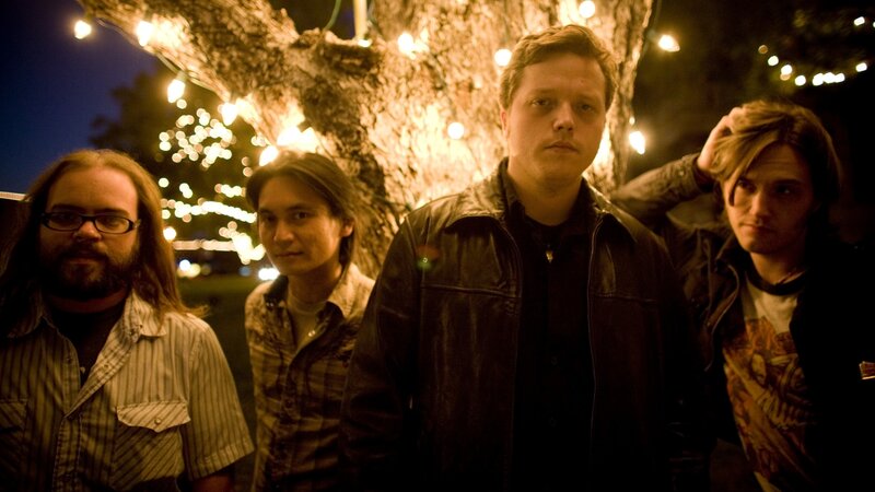 band posing under string lights