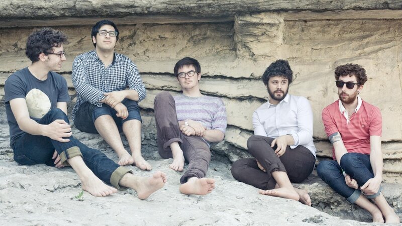 band sitting on rocks