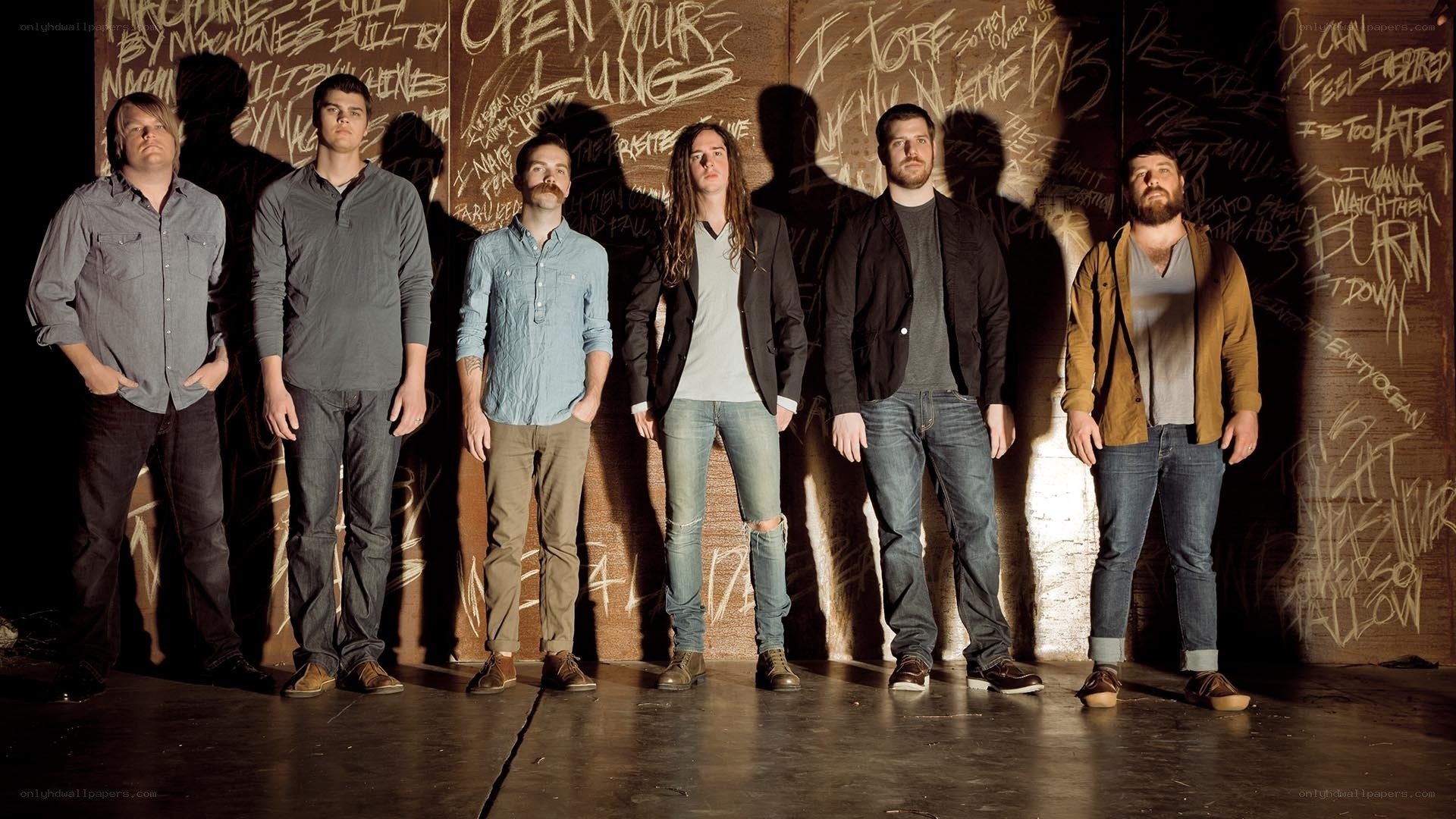 band standing in front of graffiti wall