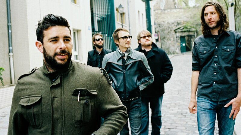 band walking on cobblestone street
