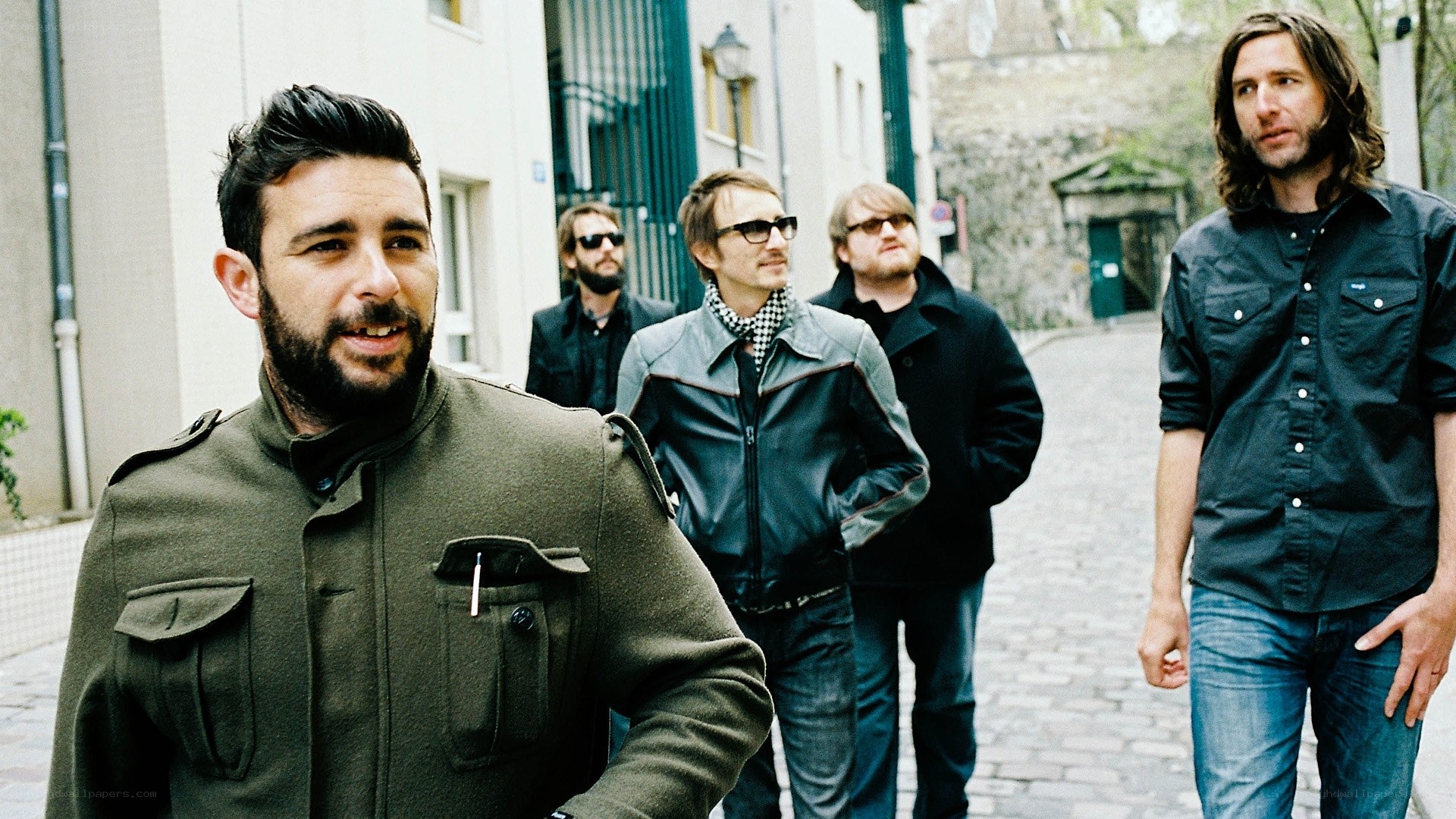 band walking on cobblestone street