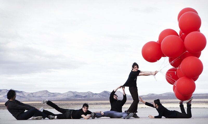 band with red balloons in desert