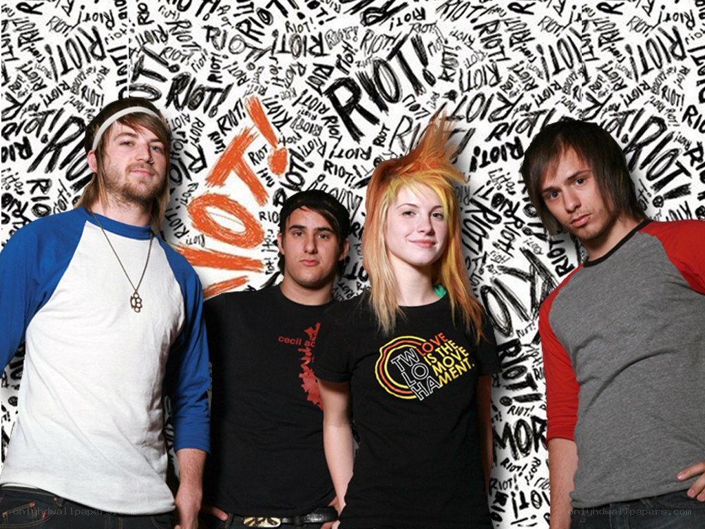band with 'RIOT!' background