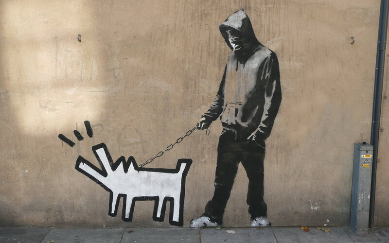 Banksy graffiti of hooded figure