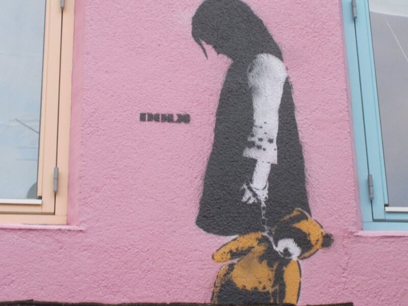 Banksy mural of girl with teddy bear