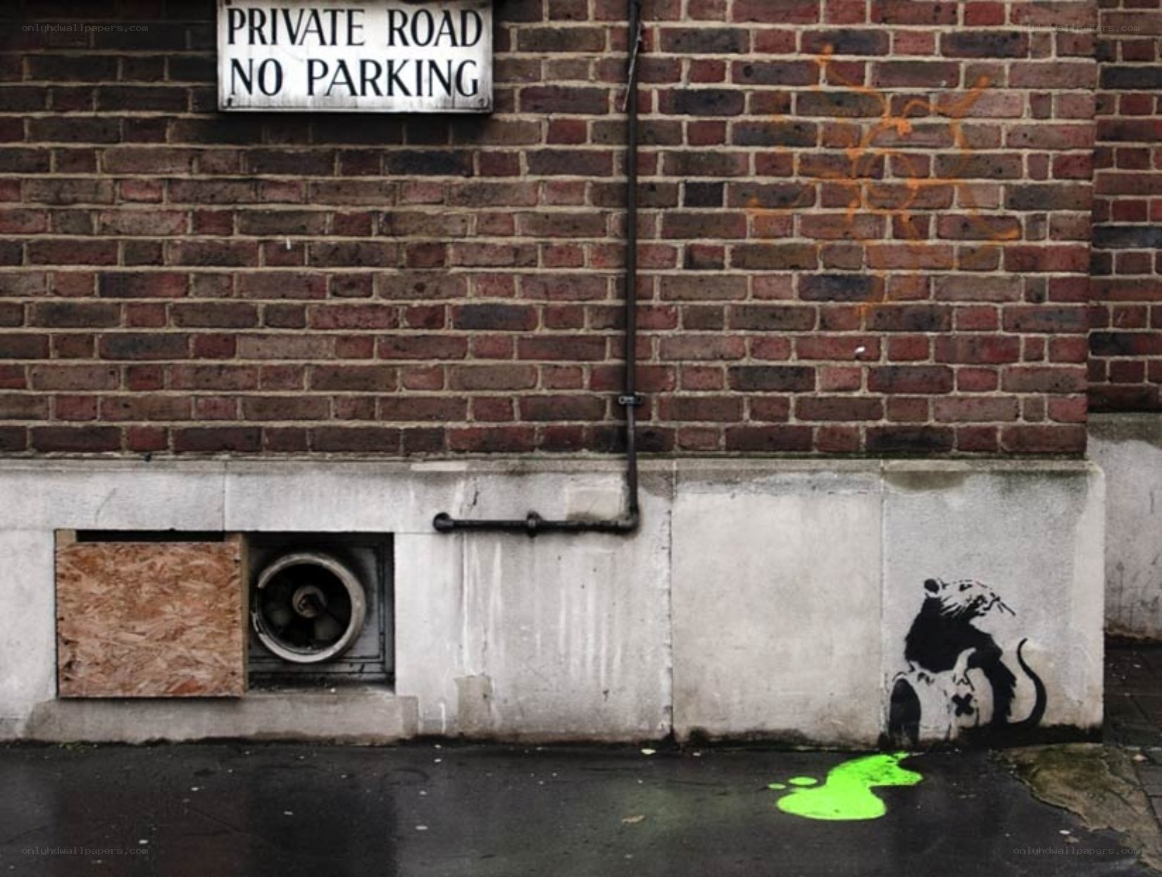 Banksy rat graffiti on brick wall