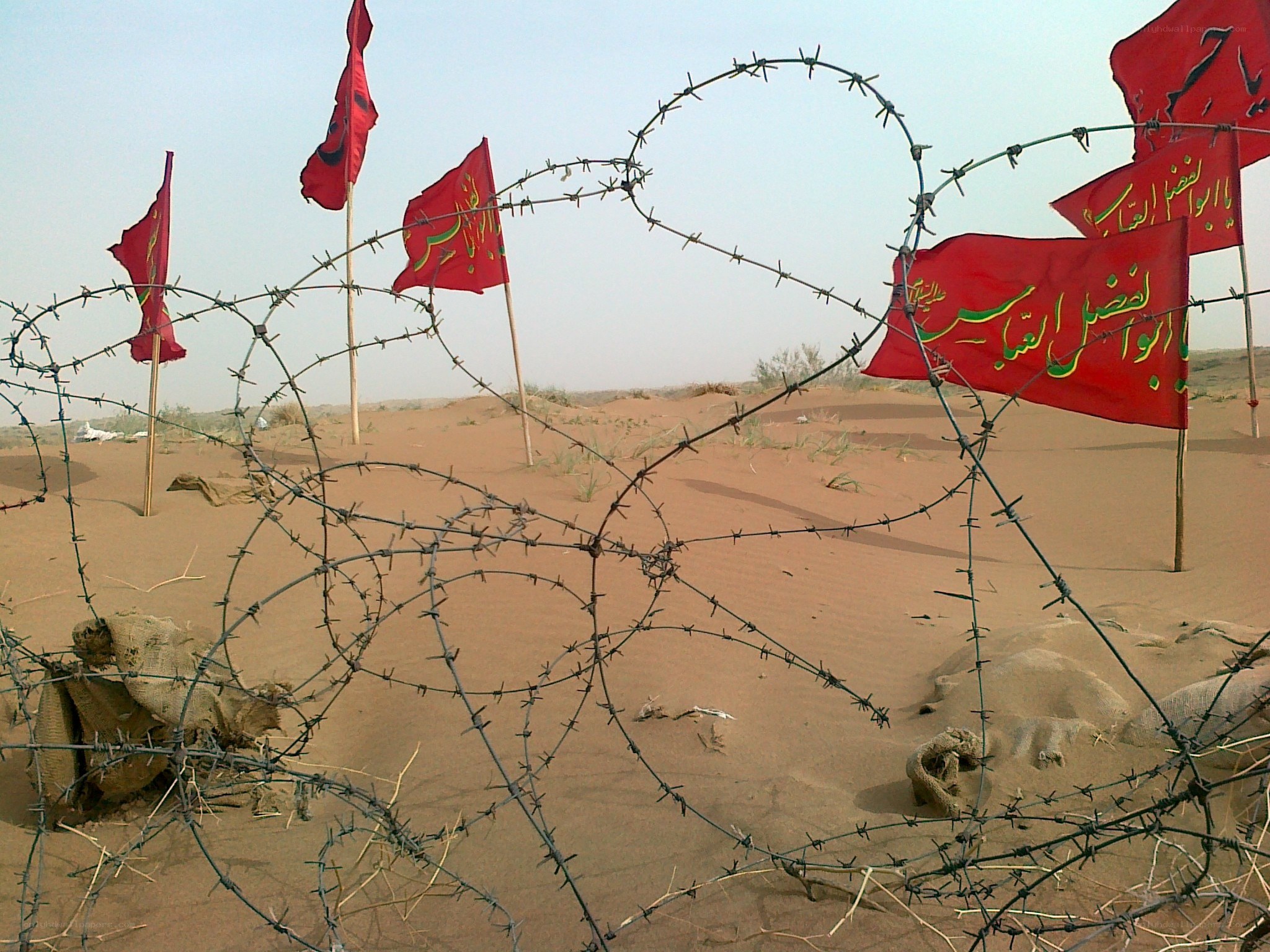 Barbed wire and flags in desert
