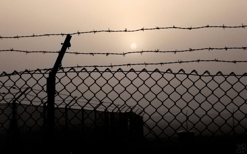 Barbed wire fence at sunset