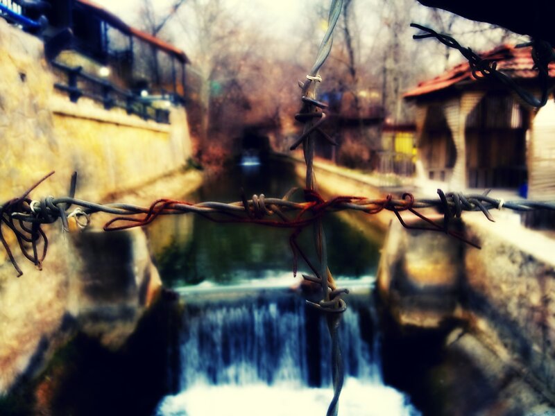 Barbed wire over small waterfall