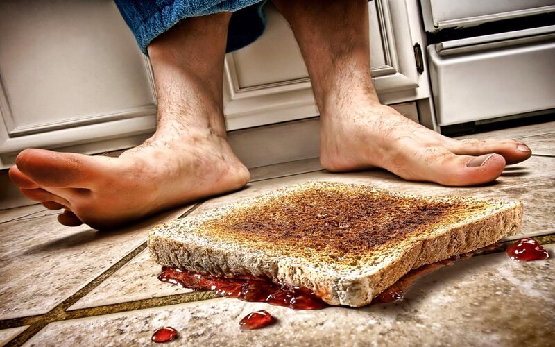 Bare feet near a dropped sandwich