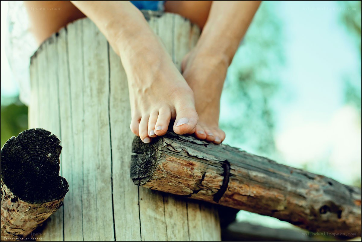 bare feet on wooden log