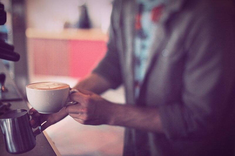 Barista serving a latte