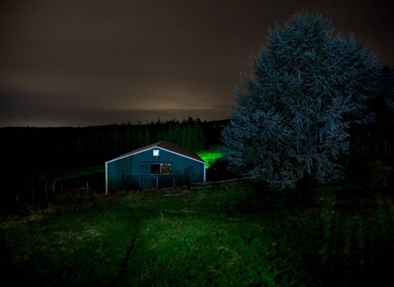 Barn at night with green light