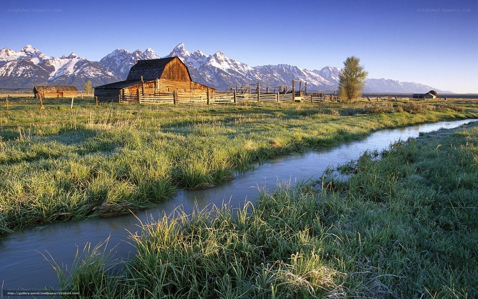 Barn by a river with mountains