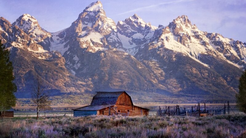 Barn in front of snow-capped mountains