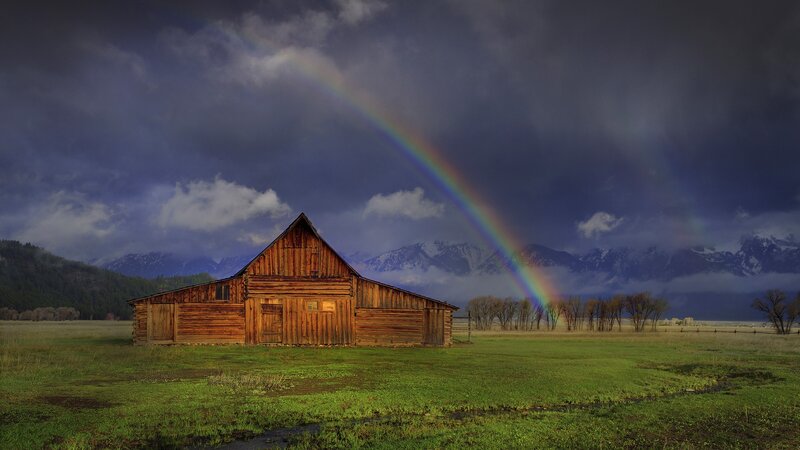 Barn with rainbow and mountains