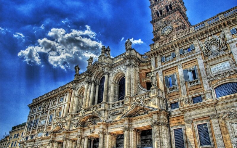 Baroque church facade under dramatic sky