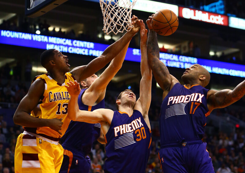 Basketball players contesting a shot