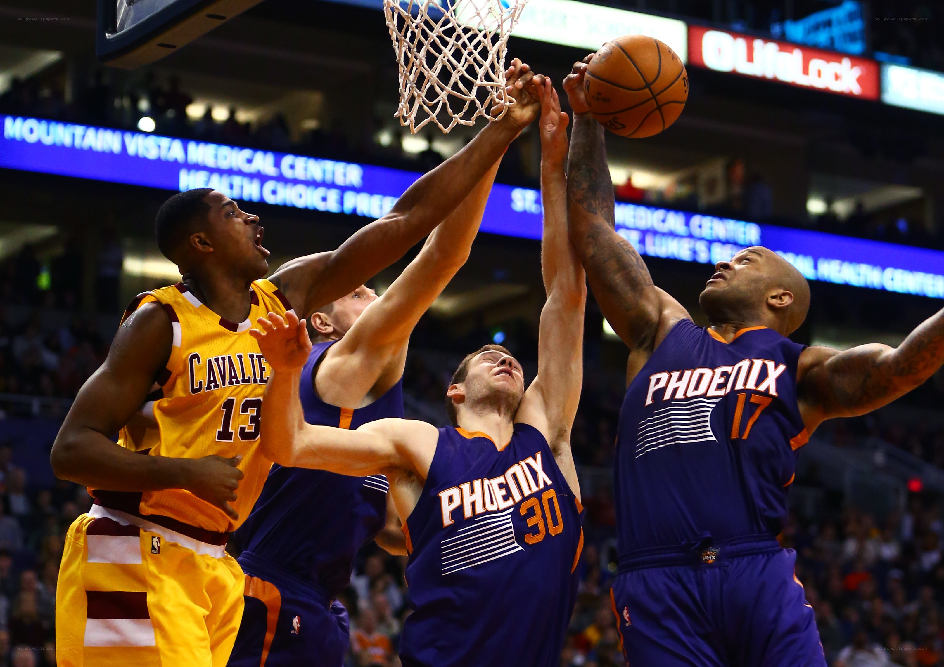 Basketball players contesting a shot