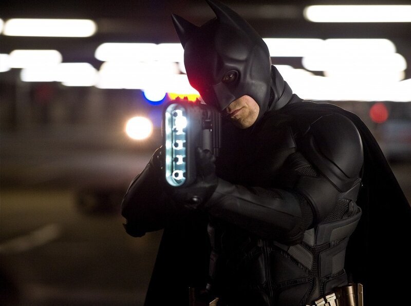 Batman holding a device