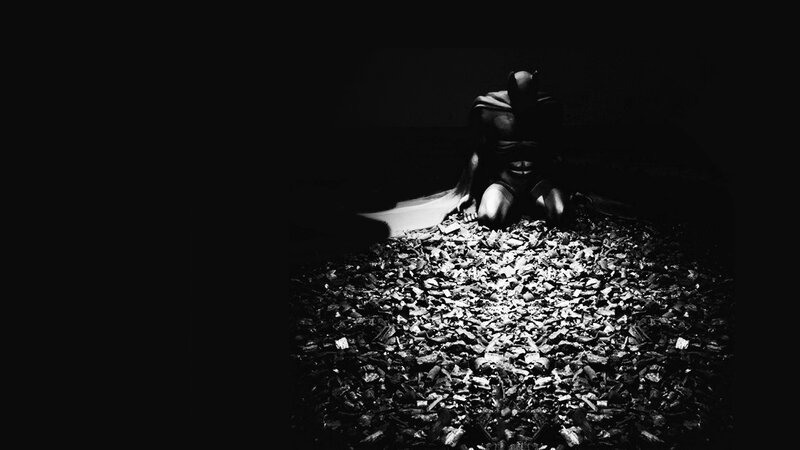 Batman kneeling in darkness