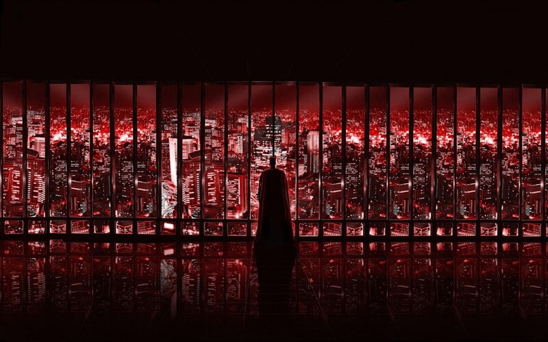 Batman overlooking a red city