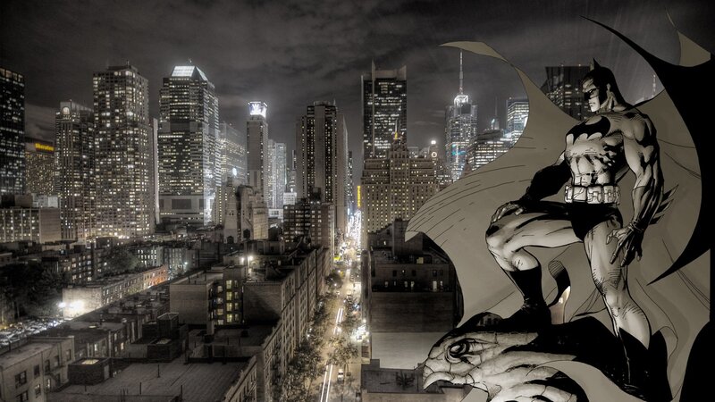 Batman overlooks a city at night